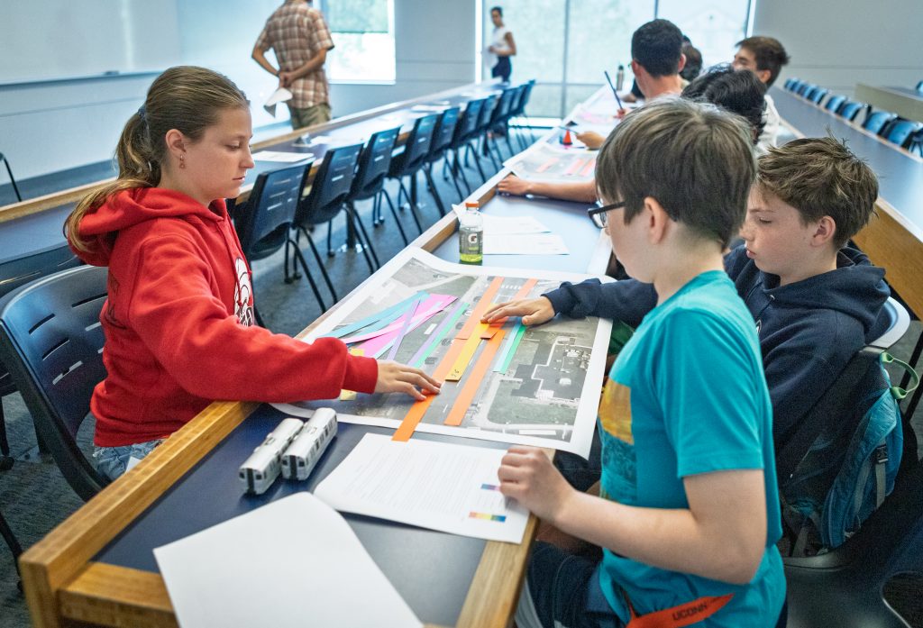 A group of students completing an activity with maps and colored strips of paper at Explore Engineering Day.