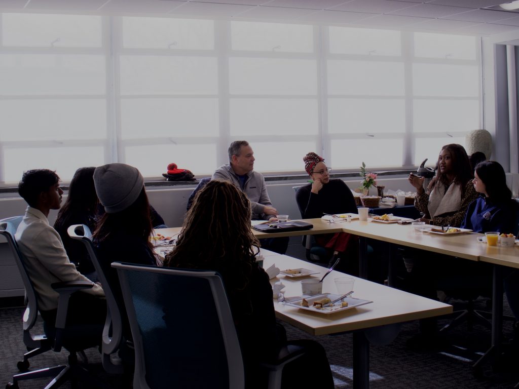 VII Staff and student leaders gathered around a table to talk with Mark Vergnano.